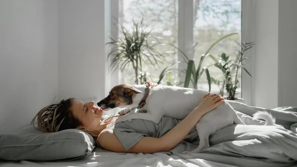 Kızlar küçük bir köpekle yataktalar.