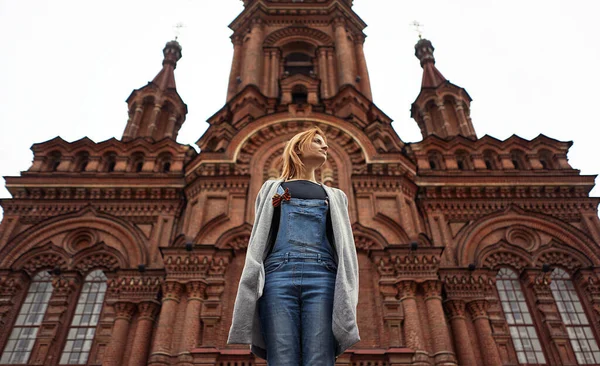 Eski kilisenin önünde duran kız, aşağıdan manzaralı.