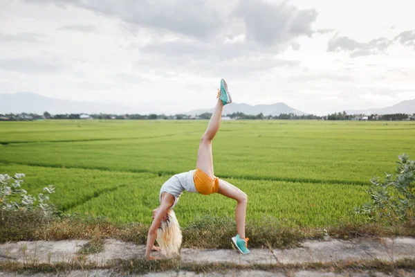 Kız pirinç tarlasında yoga yapıyor.