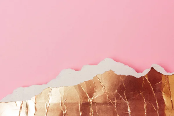 Golden abstract foil on pink paper background.