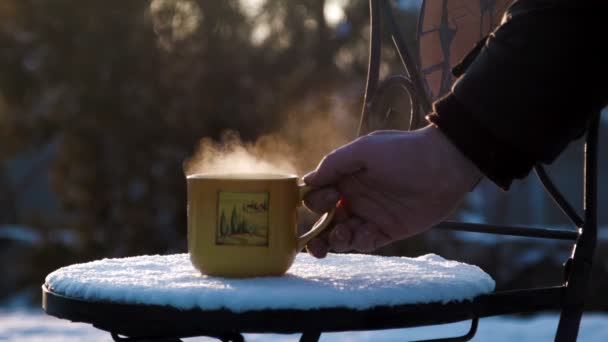 Tasse Mit Heißem Tee Auf Einem Schneebedeckten Stuhl — Stockvideo