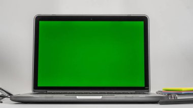 Ofis işyeri. Dizüstü bilgisayar, dizüstü bilgisayar, günlük planlayıcısı, gözlük ve beyaz arka plan üzerinde telefon. Yeşil arka plan (chromakey) dizüstü bilgisayar ve telefon