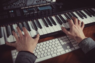 Kayıt stüdyosu, eller odaklanmak MIDI klavye synthesizer oynayan erkek müzisyen. Mens silah çalış solo müzik veya yeni melodi. Yakın çekim