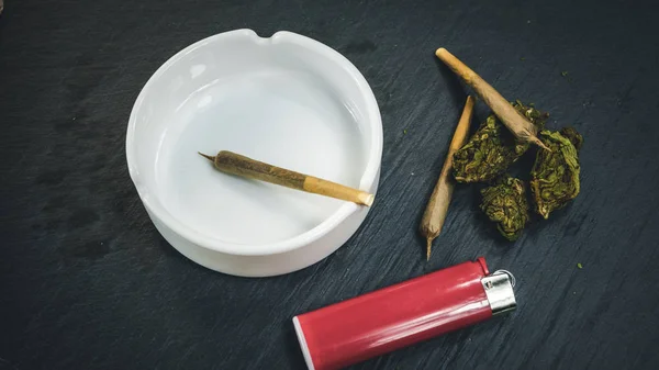 Marihuana-Knospen und Joint liegen auf dunkelgrauem Hintergrund. Marihuana — Stockfoto