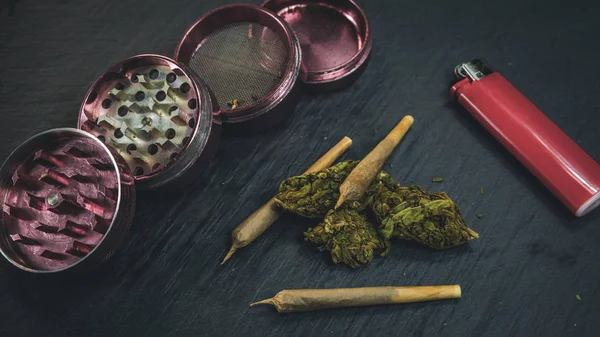 Marihuana-Knospen und Joint liegen auf dunkelgrauem Hintergrund. Schleifer — Stockfoto