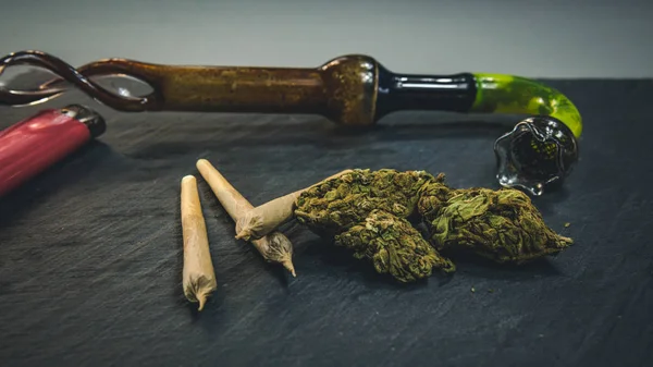 Marihuana-Knospen und Joint liegen auf dunkelgrauem Hintergrund. Rauchen — Stockfoto
