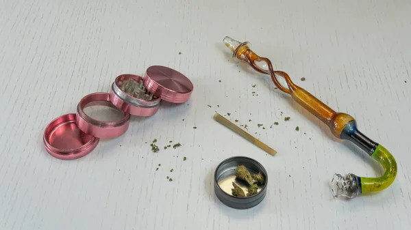 Junta de maconha, botões, moedor e cachimbo de fumar estão no branco — Fotografia de Stock