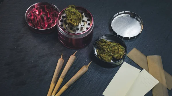 Tıbbi marihuana tomurcukları, eklem ve öğütücü koyu gri backg yalan