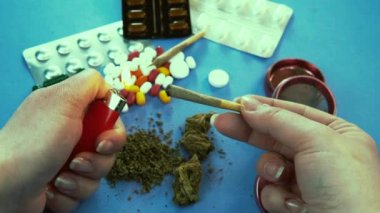 Tıbbi marihuana esrarı içen kişi. Haplar arka planda. Bitkisel ilaç