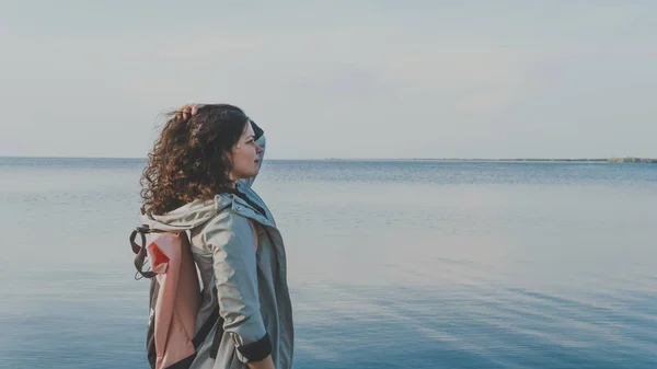 Задумчивая женщина, стоящая у моря . — стоковое фото