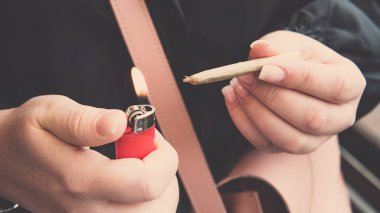 Kadın elinde marihuana eklemi yakın çekim. Kadın sigara sıhhiye