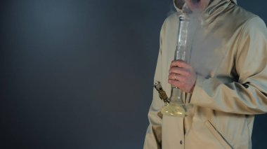 Genç kişi bong ile tıbbi marihuana sigara. 