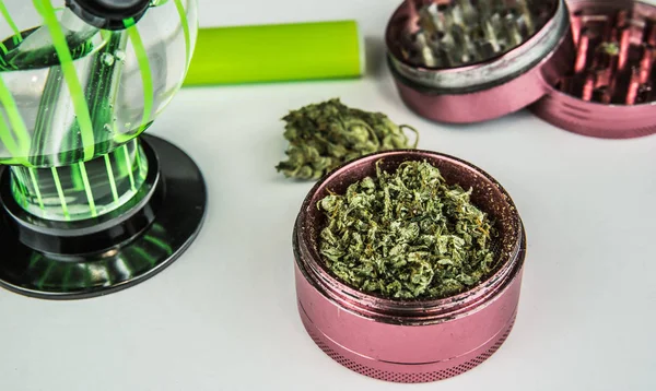 Bourgeons de marijuana médicale avec bong et broyeur gros plan . — Photo