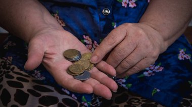 Yaşlı kadın sadaka için yalvarıyor. P elinde para ve sikke closeup