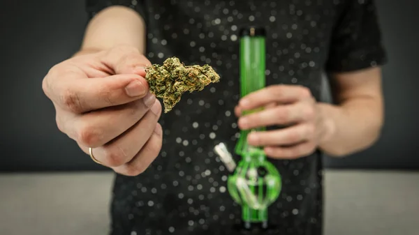 Der junge Mensch hält medizinische Marihuana-Knospen und Bonbons in der Hand — Stockfoto