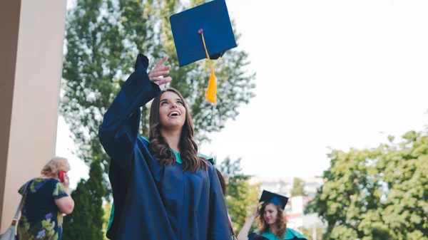 Graduados de la universidad lanzando sombreros de graduación en el aire. Grupo —  Fotos de Stock