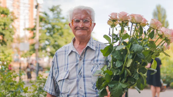 Porträtt av en äldre man stående på gatan med en bukett — Stockfoto