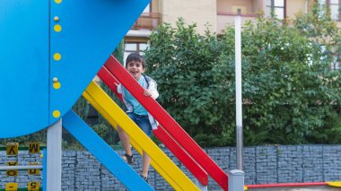 Oyun alanında mutlu gülümseyen çocuk. Dışarıda oynayan mutlu çocuklar