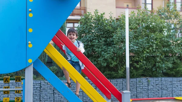 Счастливого улыбающегося ребенка на детской площадке. Счастливые дети играют на открытом воздухе — стоковое фото