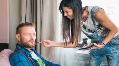 Makyaj sanatçısı genç adam için profesyonel makyaj yapıyor. Adam uygulamak