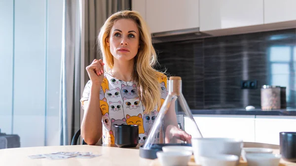Evde ki genç güzel kadın mutfakta oturuyor — Stok fotoğraf