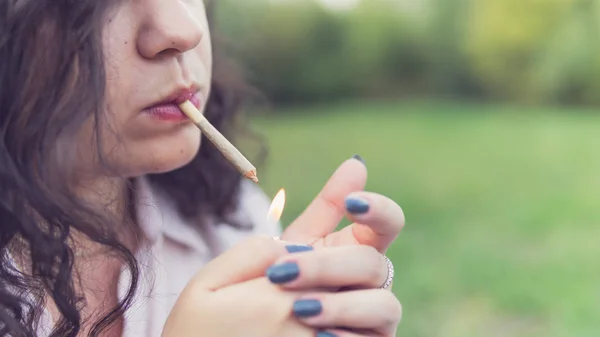 Kız açık havada tıbbi marihuana içerken, yakın çekim. Cannabi — Stok fotoğraf