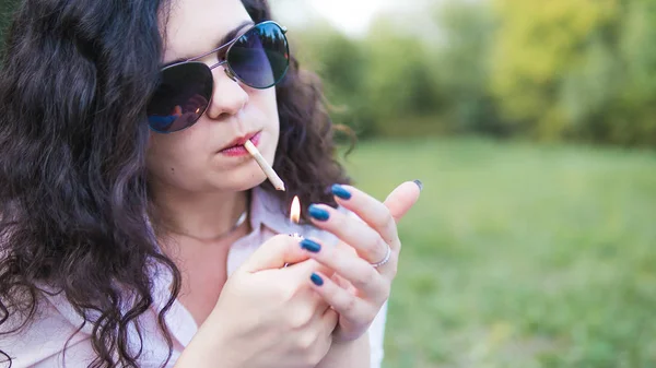 Kız açık havada tıbbi marihuana içerken, yakın çekim. Cannabi — Stok fotoğraf