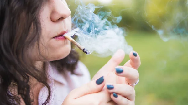 Girl smoking medical marijuana joint outdoors, close-up. Cannabi — Stock Photo, Image