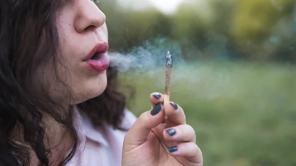 Girl smoking medical marijuana joint outdoors, close-up. Cannabi — Stock Photo, Image