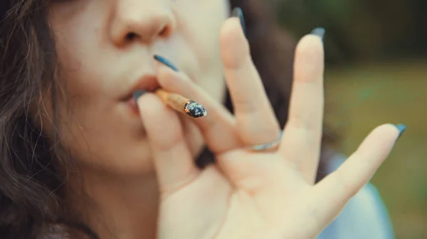 Girl smoking medical marijuana joint outdoors, close-up. Cannabi — Stock Photo, Image