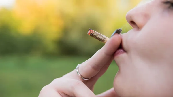 Fille fumant de la marijuana médicale en plein air, gros plan. Cannabi — Photo