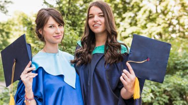 Bir grup genç kadın mezun. Kadın mezun ag gülümsüyor