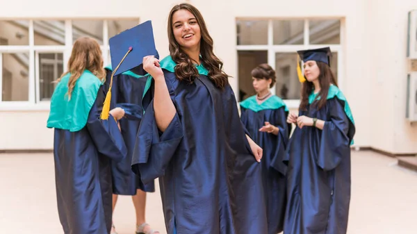 Un grupo de jóvenes graduadas. Mujer graduada es sonriente ag —  Fotos de Stock