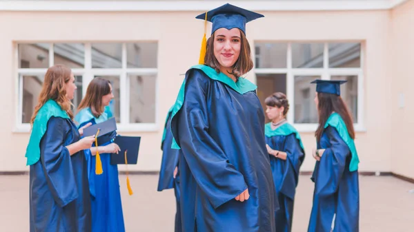 Um grupo de jovens graduadas. Feminino graduado está sorrindo ag — Fotografia de Stock