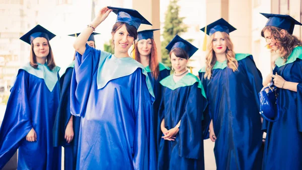 Un grupo de jóvenes graduadas. Mujer graduada es sonriente ag —  Fotos de Stock