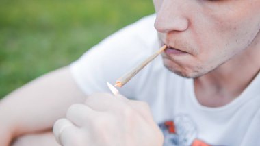 Genç kişi açık havada tıbbi marihuana ortak sigara. Y