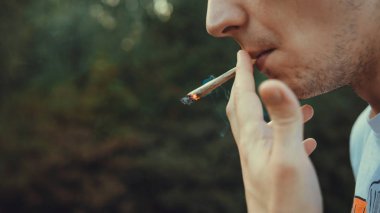 Genç kişi açık havada tıbbi marihuana ortak sigara. Y