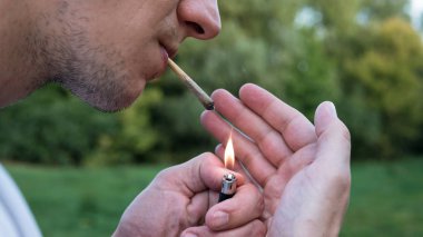 Genç kişi açık havada tıbbi marihuana ortak sigara. Y