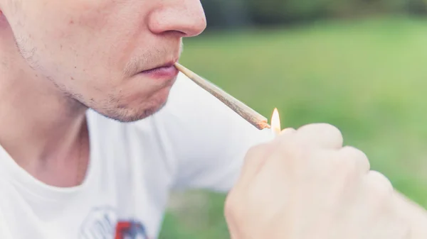 屋外で医療用マリファナジョイントを喫煙する若者。y — ストック写真