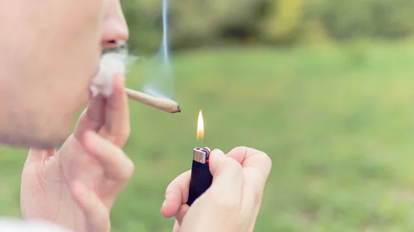 Genç kişi açık havada tıbbi marihuana ortak sigara. Y — Stok fotoğraf