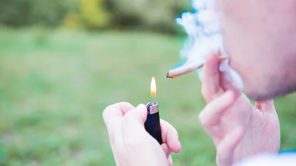 Genç kişi açık havada tıbbi marihuana ortak sigara. Y — Stok fotoğraf