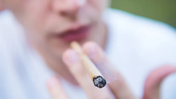 Genç kişi açık havada tıbbi marihuana ortak sigara. Y — Stok fotoğraf