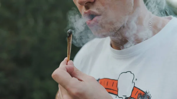 屋外で医療用マリファナジョイントを喫煙する若者。y — ストック写真