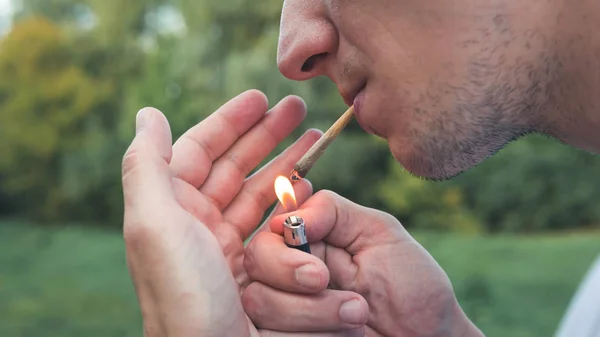 Молода людина палить медичну марихуану на відкритому повітрі. Наприклад Y — стокове фото