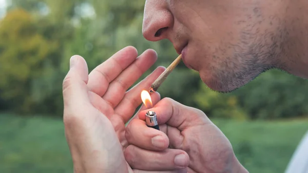 Genç kişi açık havada tıbbi marihuana ortak sigara. Y