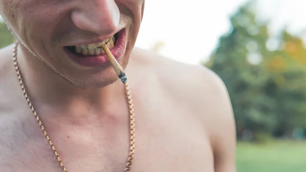 The young person smoking medical marijuana joint outdoors. The y