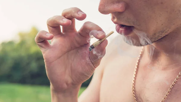 Der Jugendliche raucht im Freien medizinischen Marihuana-Joint. das y — Stockfoto