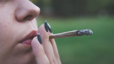Genç kişi açık havada tıbbi marihuana ortak sigara. Y
