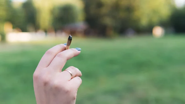 Primer plano de las manos de las mujeres que sostienen la marihuana conjunta, fumar canna —  Fotos de Stock