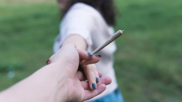 Primer plano de las manos de las mujeres que sostienen la marihuana conjunta, fumar canna —  Fotos de Stock